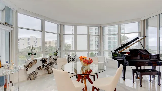 a kitchen with stainless steel appliances kitchen island granite countertop a table chairs and a refrigerator