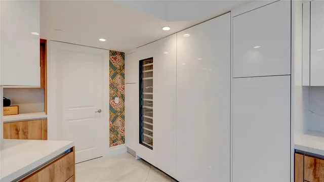 a view of a hallway with bathroom and wooden floor