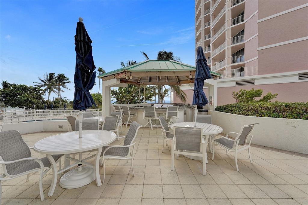 1440 South Ocean Boulevard, Unit 5C Pompano Beach, FL 33062 - Photo 67 of 71 a view of a patio with a table and chairs and potted plants