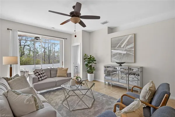 a living room with furniture ceiling fan and a window