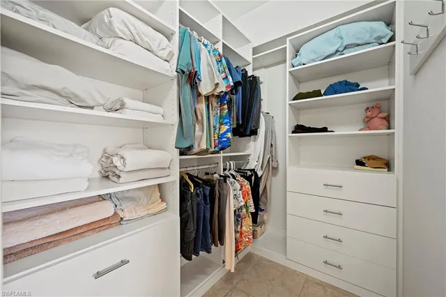 a view of walk in closet with clothes and shoes