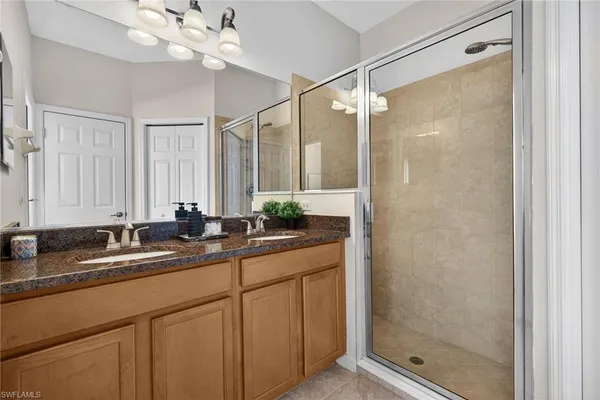 a en suite bathroom with a double vanity sink and a mirror