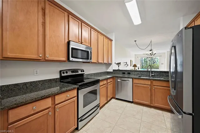 a kitchen with stainless steel appliances granite countertop a refrigerator sink and stove