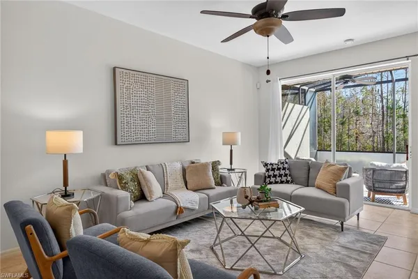 a living room with lots of white furniture and couches with wooden floor