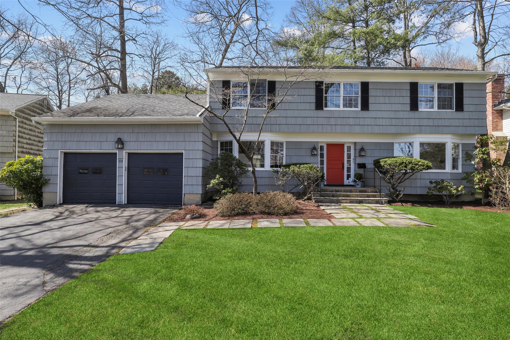 a front view of a house with a garden and plants