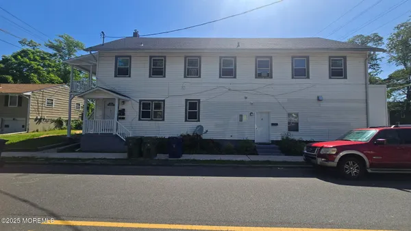 a front view of a house with a parking space