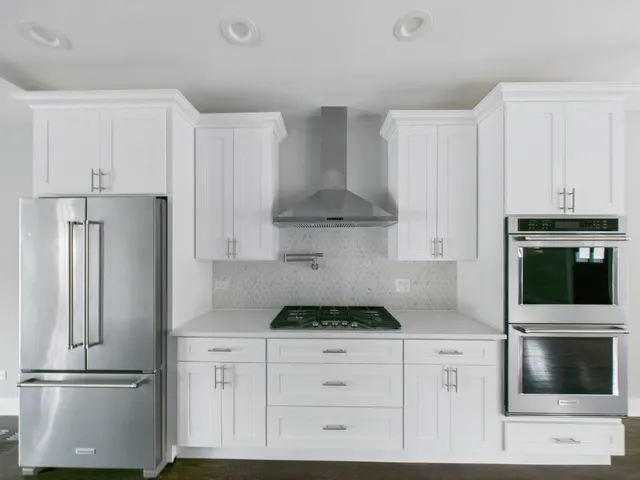 a kitchen with white cabinets and stainless steel appliances