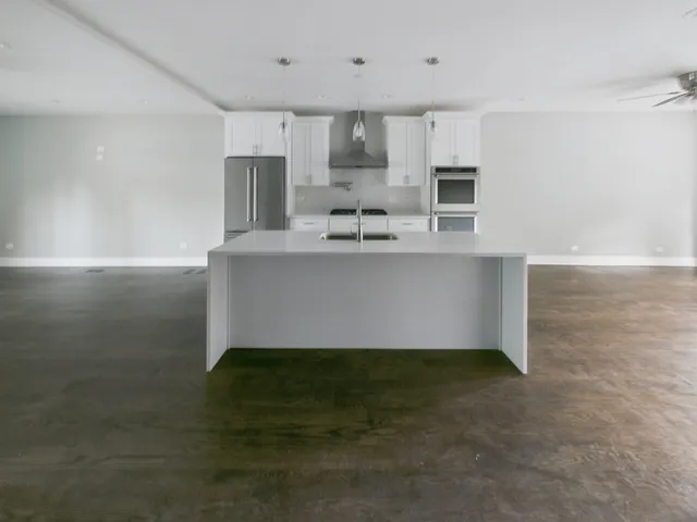 a kitchen with kitchen island a sink stainless steel appliances and cabinets