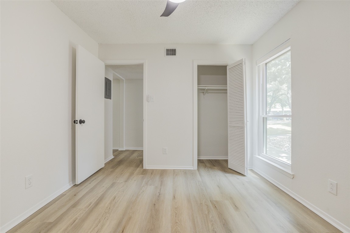 8600 Fathom Circle, Unit 1303 Austin, TX 78750 - Photo 11 of 30 an empty room with wooden floor closet and windows
