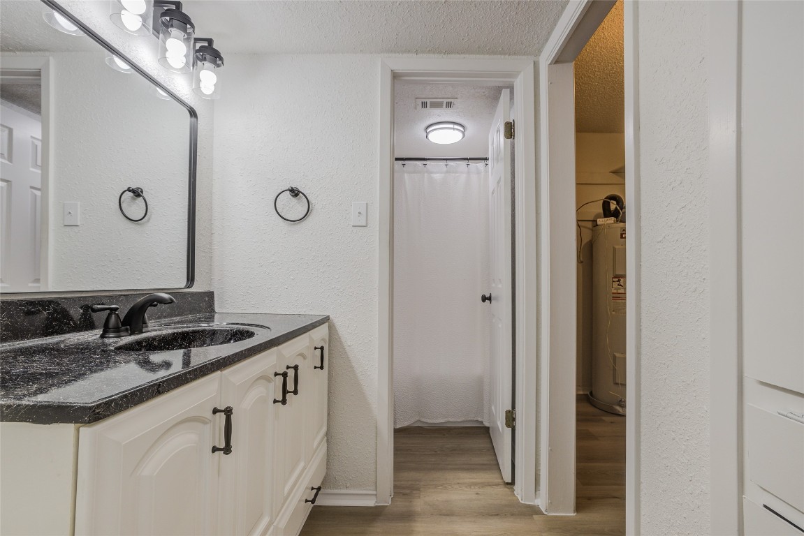 8600 Fathom Circle, Unit 1303 Austin, TX 78750 - Photo 18 of 30 a bathroom with a granite countertop sink and a mirror