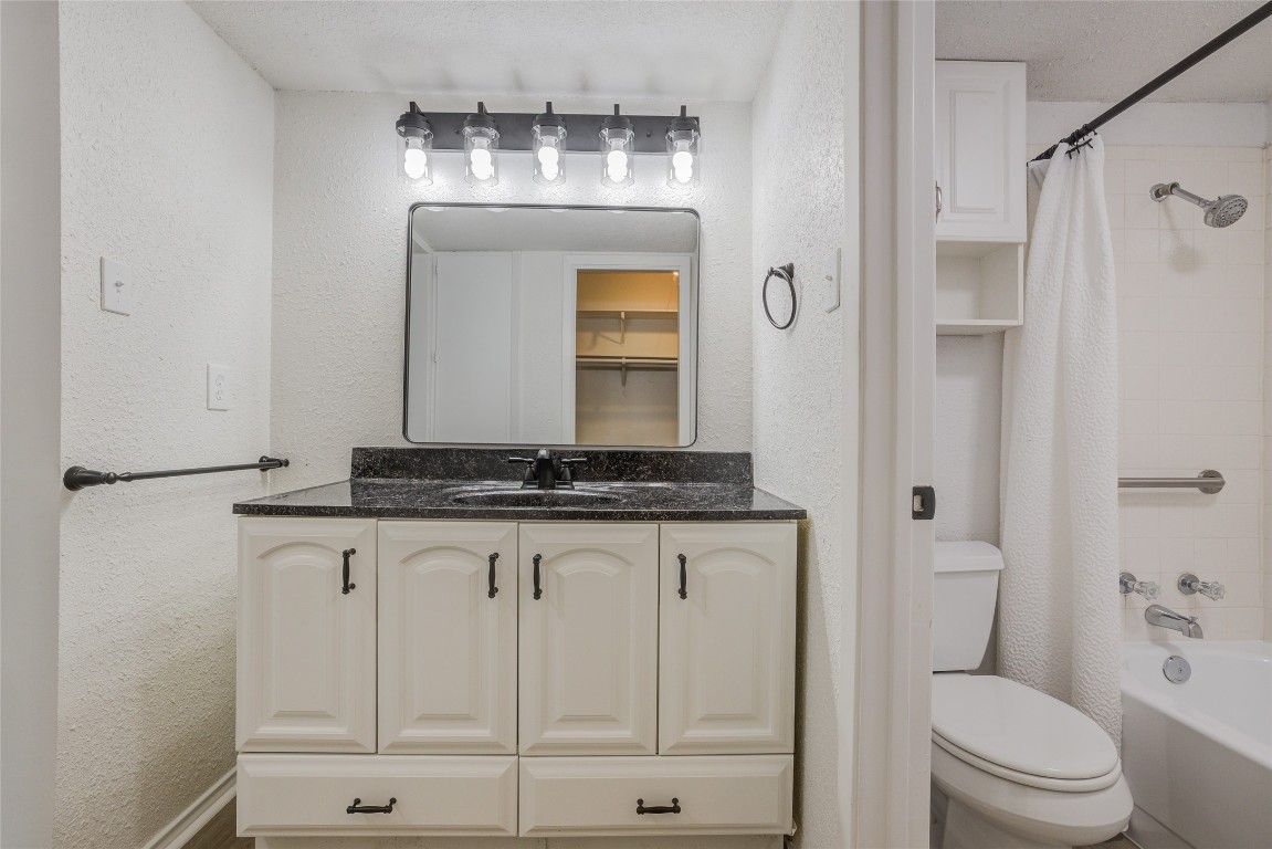 8600 Fathom Circle, Unit 1303 Austin, TX 78750 - Photo 19 of 30 a bathroom with a granite countertop sink a toilet and a mirror