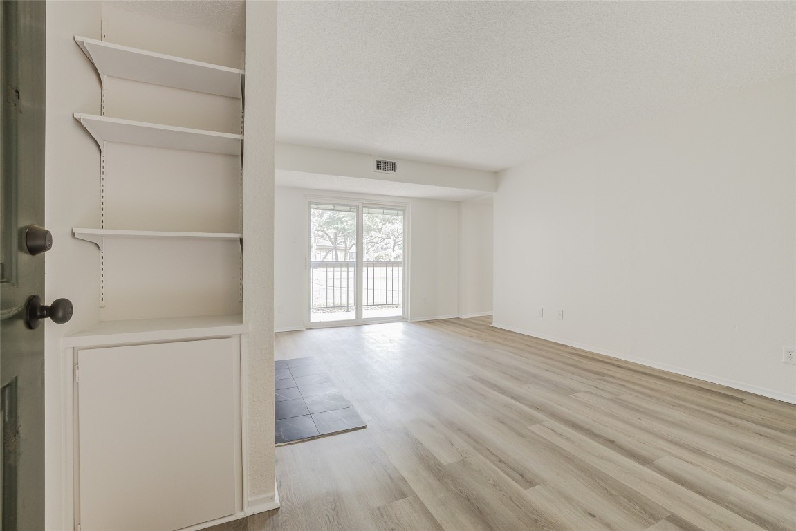 8600 Fathom Circle, Unit 1303 Austin, TX 78750 - Photo 4 of 30 an empty room with wooden floor and windows