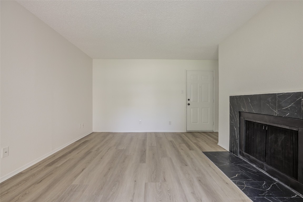 8600 Fathom Circle, Unit 1303 Austin, TX 78750 - Photo 7 of 30 an empty room with wooden floor and fireplace