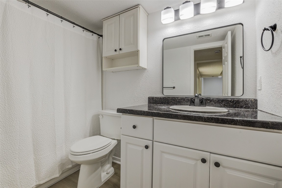 8600 Fathom Circle, Unit 1303 Austin, TX 78750 - Photo 9 of 30 a bathroom with a toilet a sink and mirror