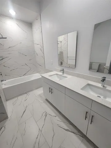 a spacious bathroom with a bathtub sink and mirror