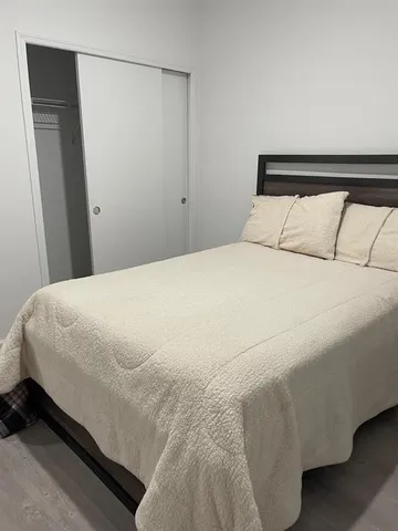 a large bed sitting in a bedroom next to a window