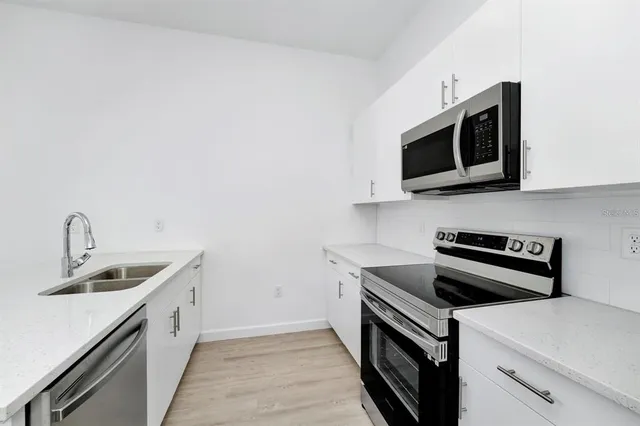 a kitchen with stainless steel appliances granite countertop a sink stove and microwave