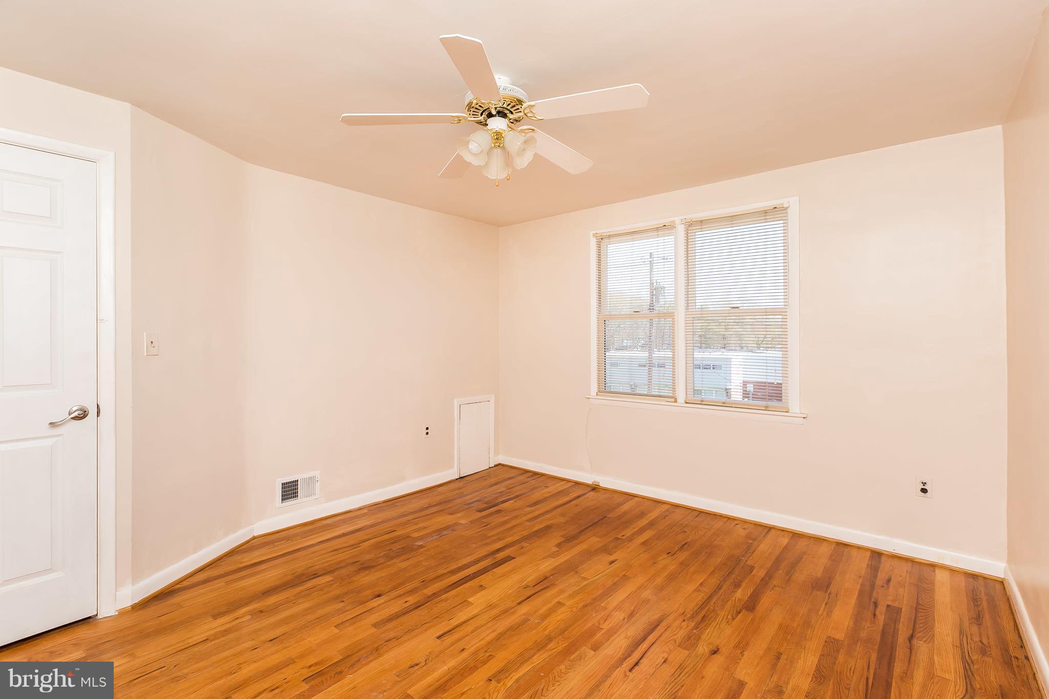 1693 Poles Road Baltimore, MD 21221 - Photo 11 of 19 a view of a room with wooden floor and a ceiling fan
