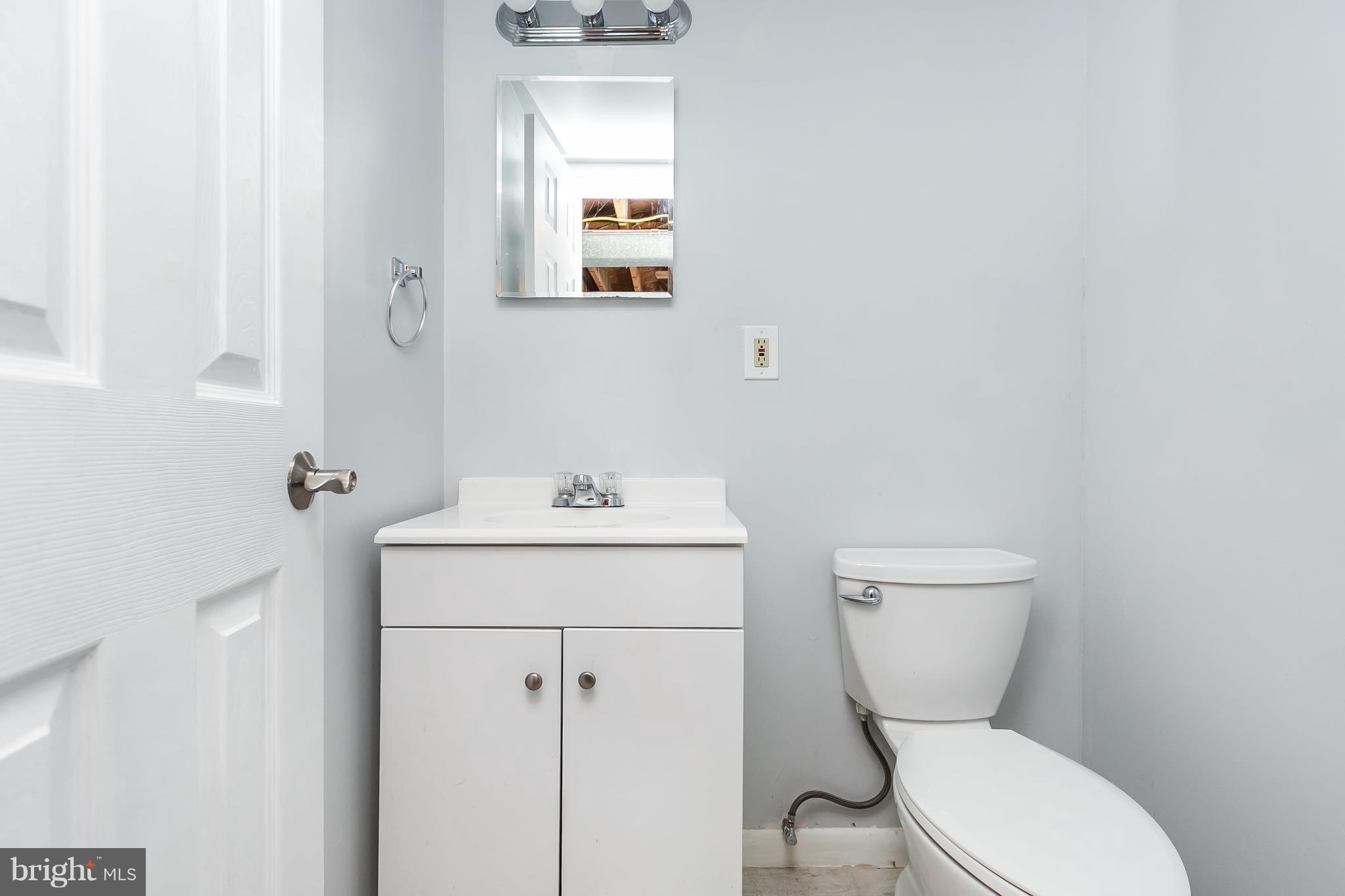 1693 Poles Road Baltimore, MD 21221 - Photo 16 of 19 a white toilet sitting next to a bathroom sink