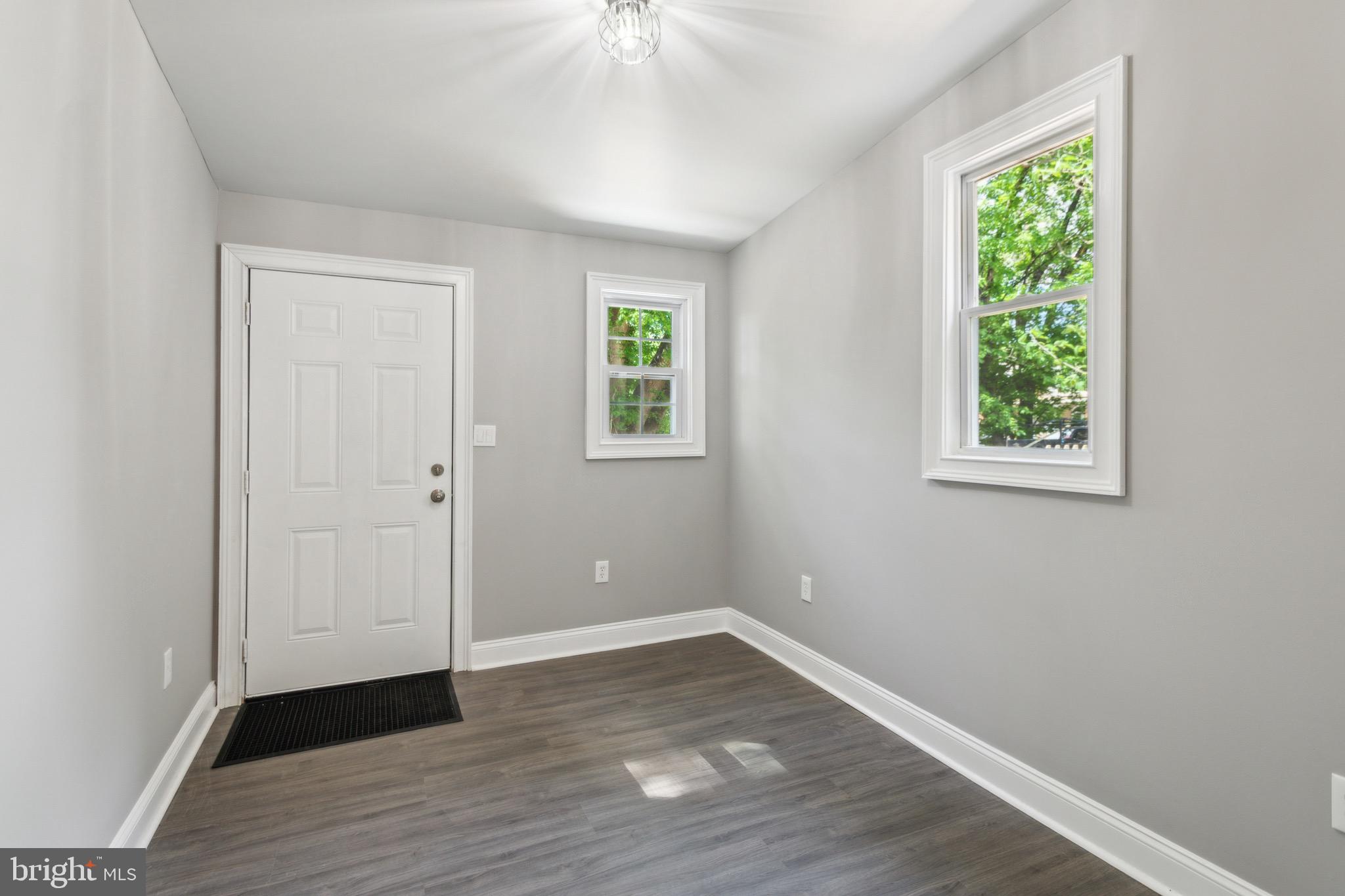 1613 Louis Street Camden, NJ 08104 - Photo 11 of 22 an empty room with wooden floor and windows