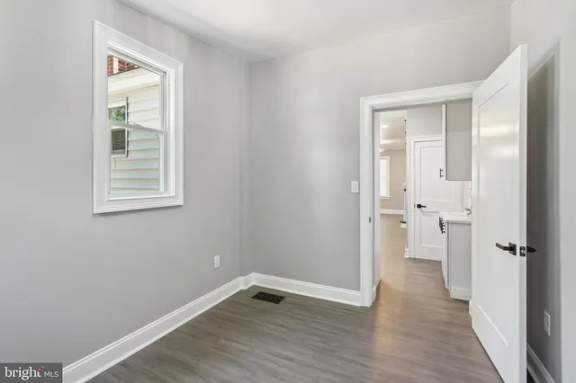 an empty room with wooden floor and a window