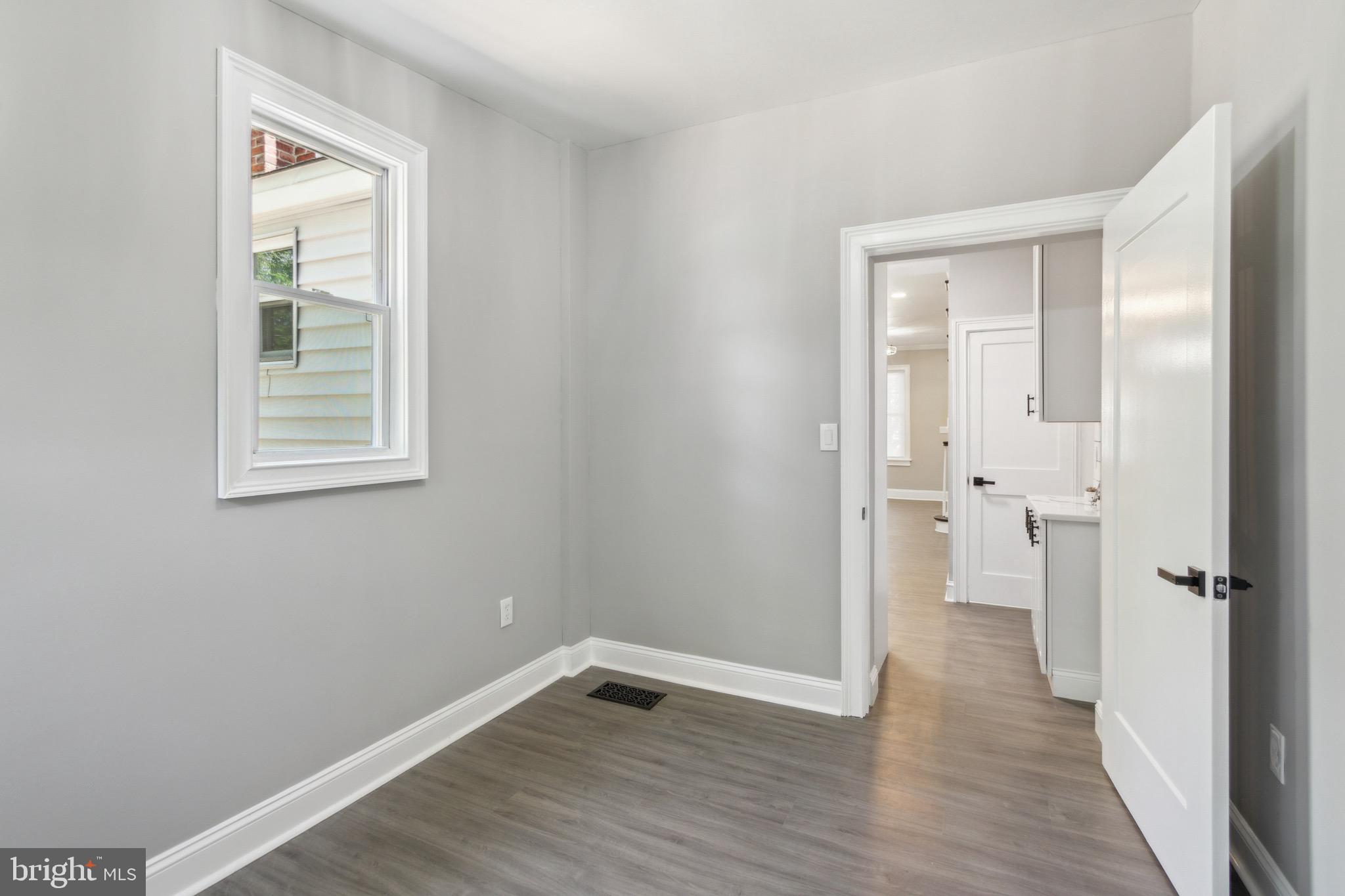 1613 Louis Street Camden, NJ 08104 - Photo 12 of 22 an empty room with wooden floor and a window