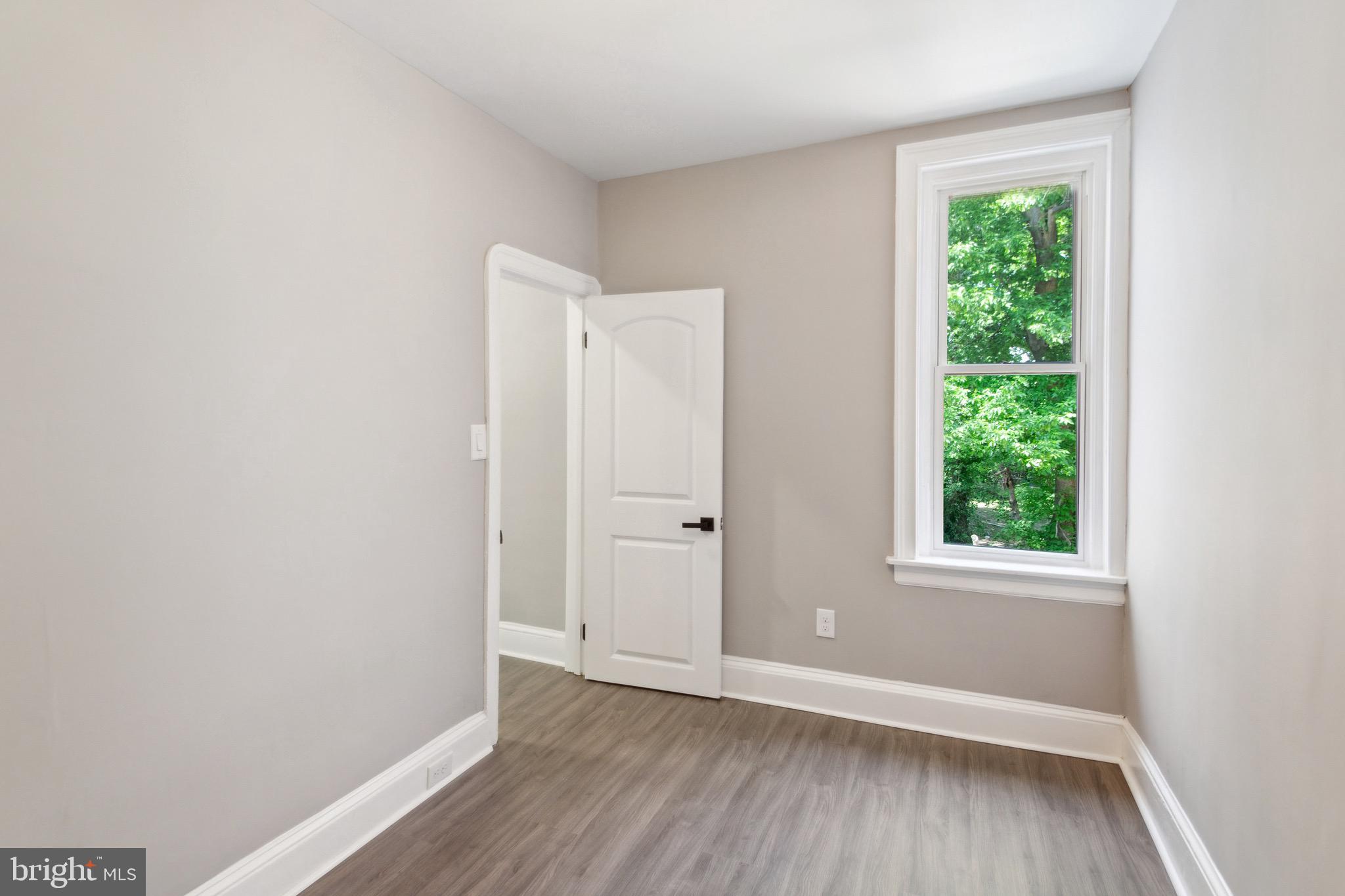 1613 Louis Street Camden, NJ 08104 - Photo 16 of 22 a view of an empty room with wooden floor and a window