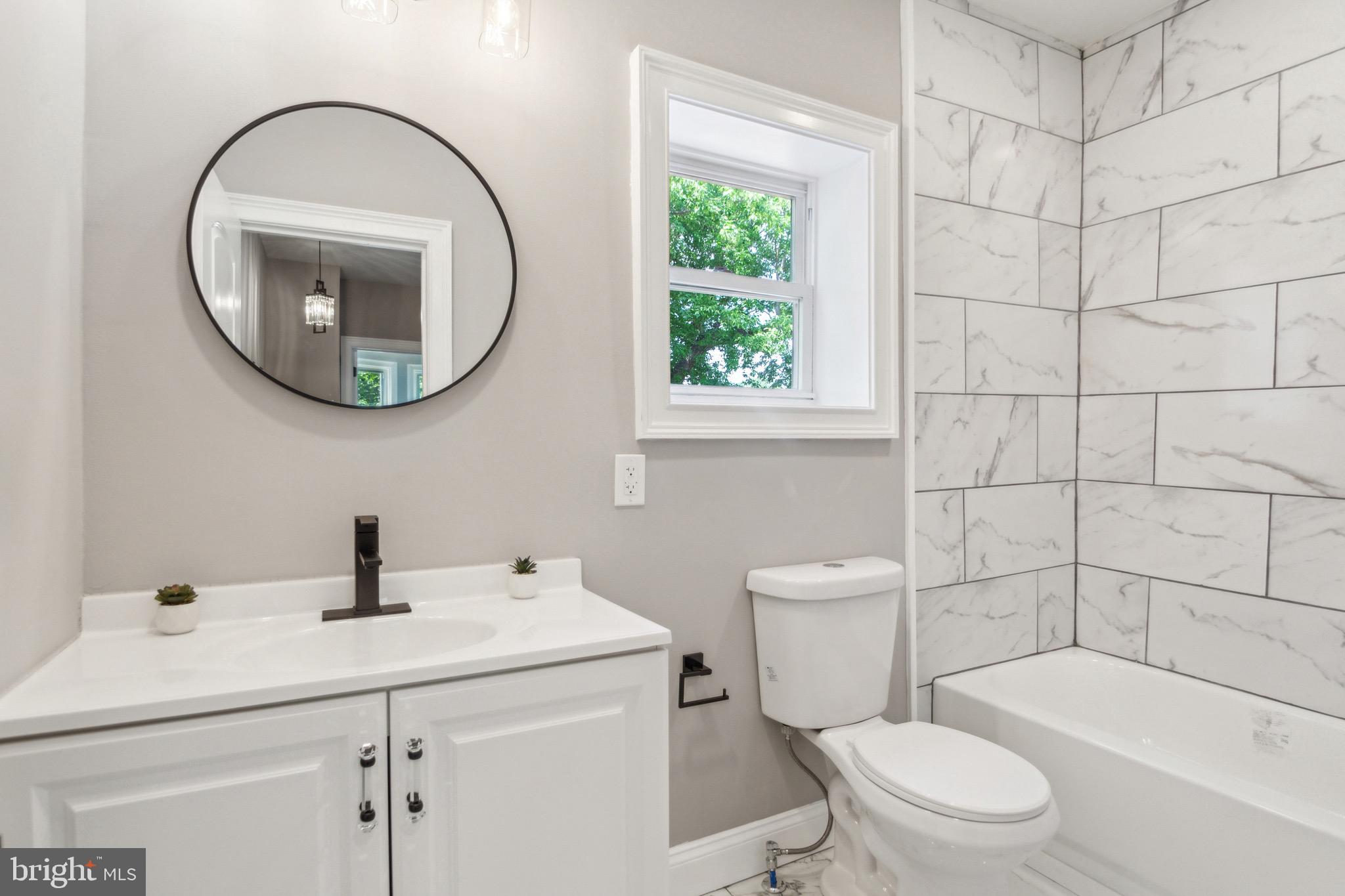 1613 Louis Street Camden, NJ 08104 - Photo 20 of 22 a bathroom with a sink a toilet and a mirror