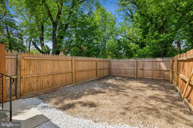 a view of backyard with wooden fence