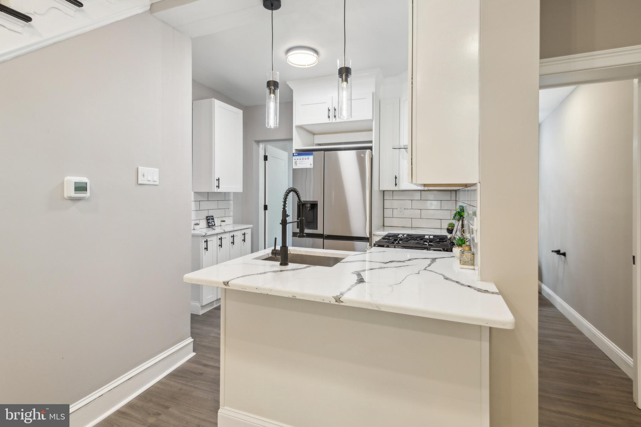 1613 Louis Street Camden, NJ 08104 - Photo 7 of 22 a kitchen with stainless steel appliances a sink and cabinets