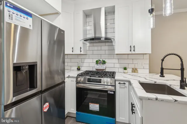 a kitchen with stainless steel appliances a stove a sink and a refrigerator