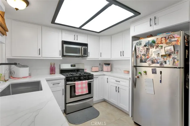 a kitchen with stainless steel appliances granite countertop a refrigerator sink and stove