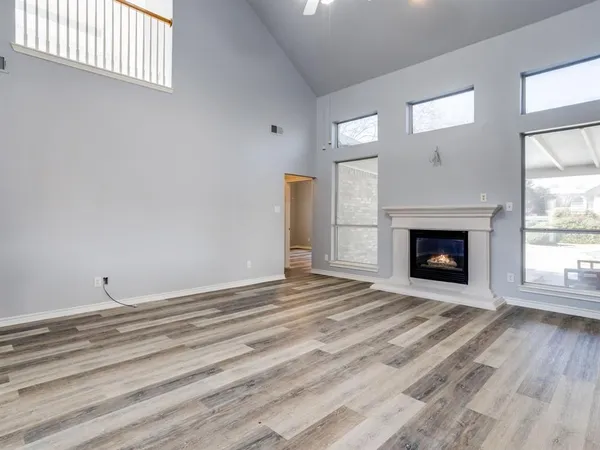 a view of empty room with wooden floor and fireplace