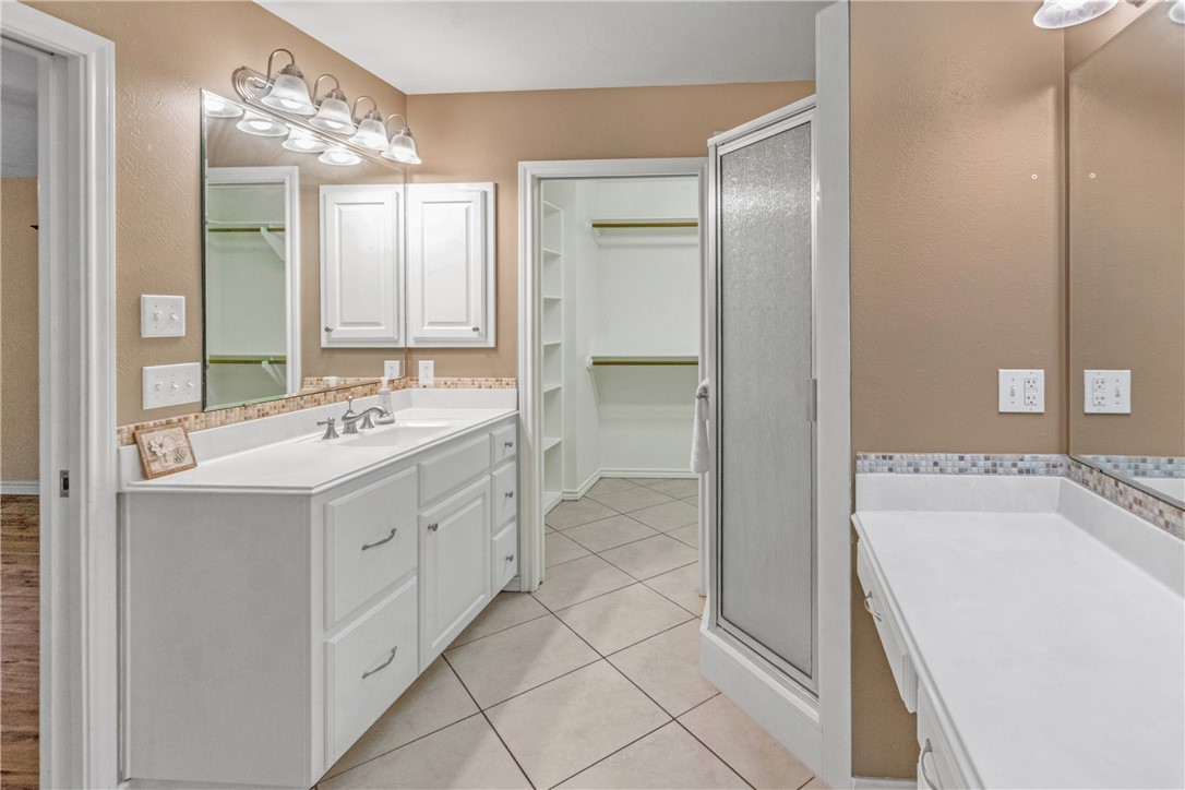 9997 Calhoun Road Bryan, TX 77808 - Photo 19 of 50 a spacious bathroom with a double vanity sink mirror and bathtub