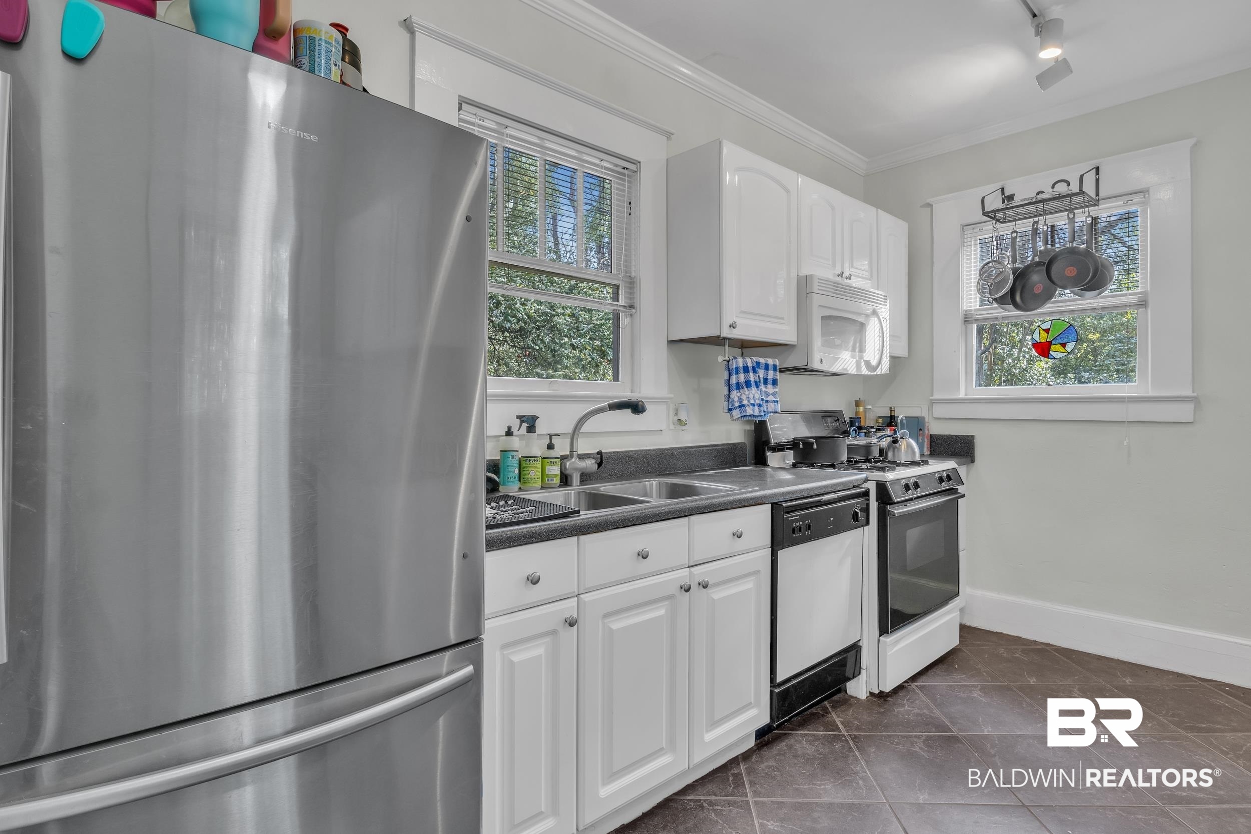 55 Mohawk Street Mobile, AL 36606 - Photo 24 of 28 Kitchen featuring white appliances, a sink, crown molding, white cabinetry, and dark countertops