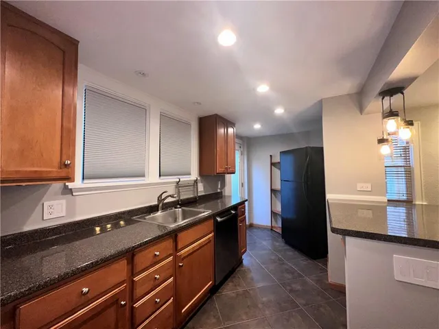 a kitchen with granite countertop a refrigerator and a sink