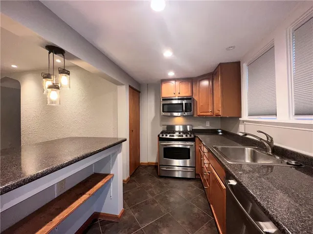 a kitchen with granite countertop stainless steel appliances and sink