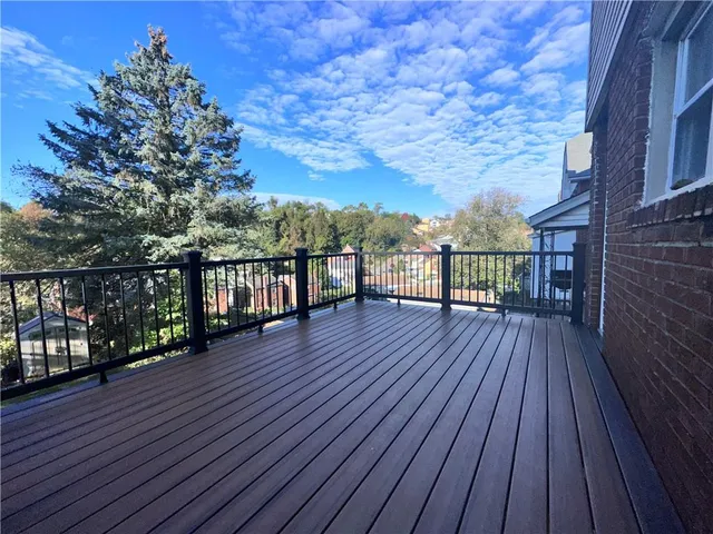 a view of a balcony with wooden floor and city view