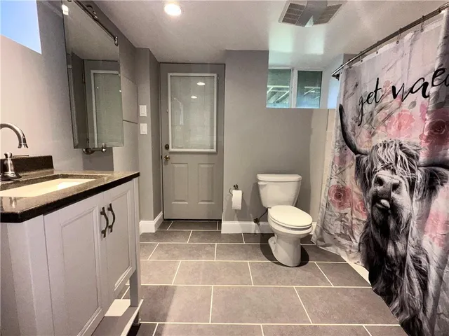 a bathroom with a toilet sink and mirror