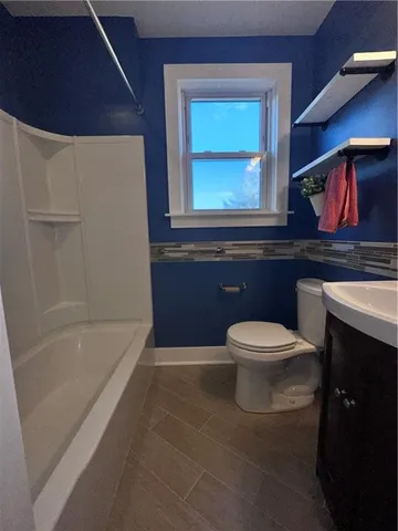 a bathroom with a toilet a sink and bathtub