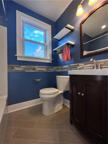 a bathroom with a toilet sink and mirror
