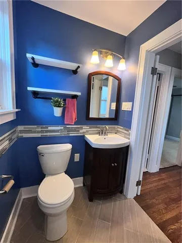 a bathroom with a toilet sink and mirror