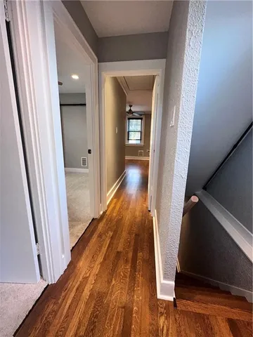 a view of a hallway with wooden floor and staircase