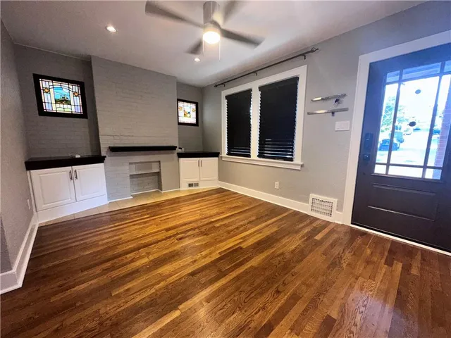 a view of a livingroom with wooden floor and windows
