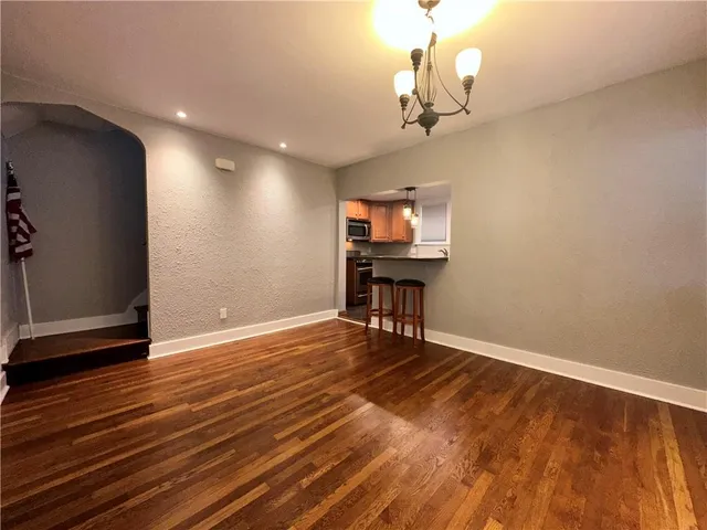 a view of a livingroom with wooden floor and a chandelier