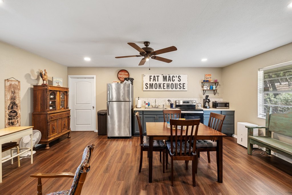 23644 Nameless Road Leander, TX 78641 - Photo 24 of 40 A welcoming kitchen and dining area featuring a breakfast bar and rich hardwood flooring, perfect for casual meals.