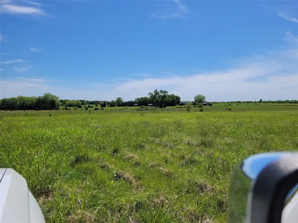 a view of a big yard with a house in the background