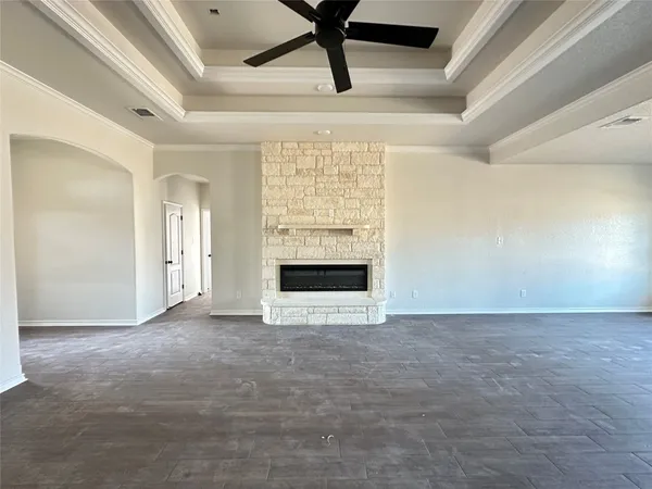 a view of an empty room with a fireplace and a window