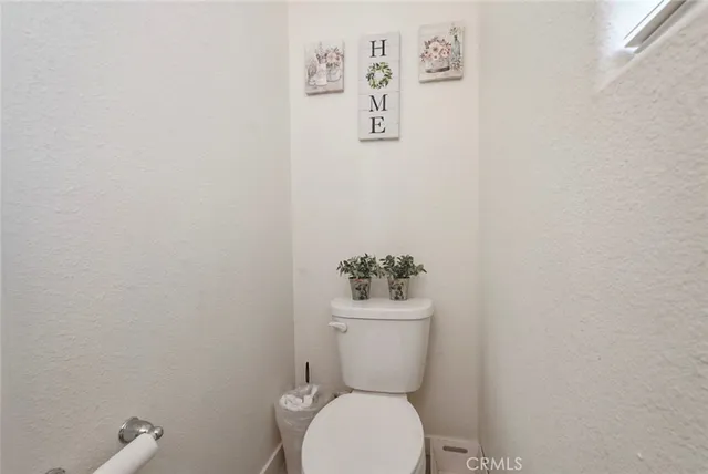 a white toilet sitting next to a white wall