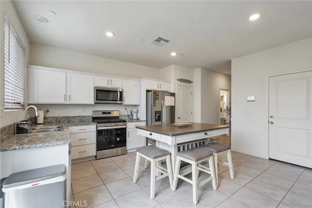 a kitchen with stainless steel appliances granite countertop a stove a sink a microwave and a refrigerator